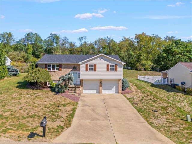 bi-level home featuring a garage and a front lawn