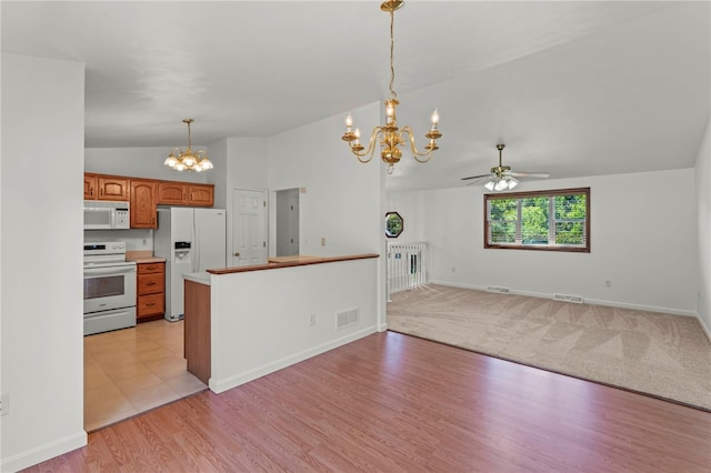 kitchen with light wood-type flooring, kitchen peninsula, white appliances, ceiling fan with notable chandelier, and vaulted ceiling