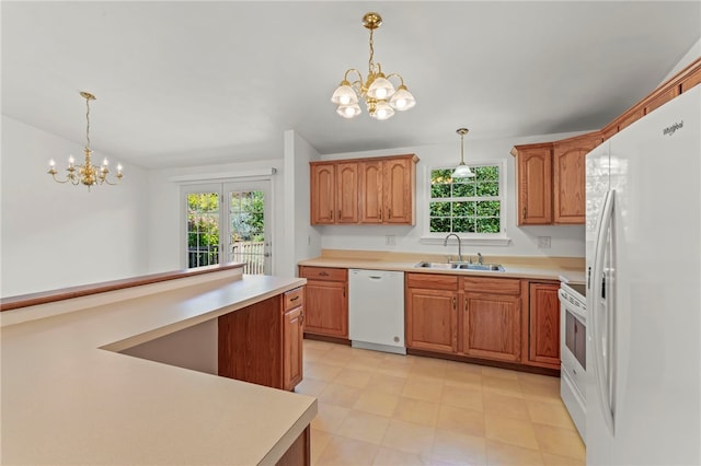 kitchen with hanging light fixtures, sink, white appliances, an inviting chandelier, and a wealth of natural light