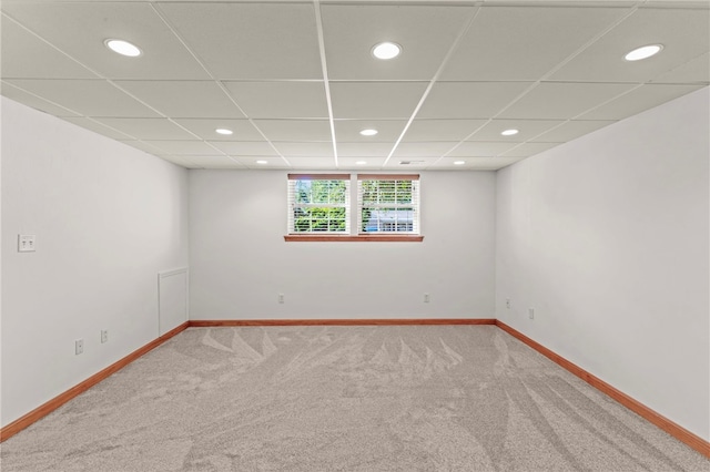 carpeted empty room with a drop ceiling