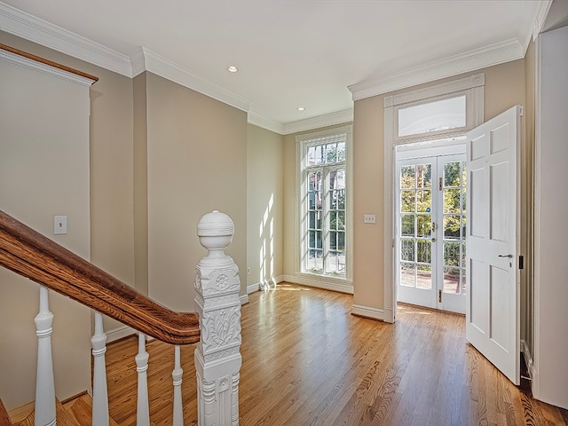 doorway to outside with crown molding and light hardwood / wood-style floors