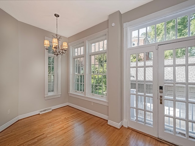 doorway with wood-type flooring and a chandelier