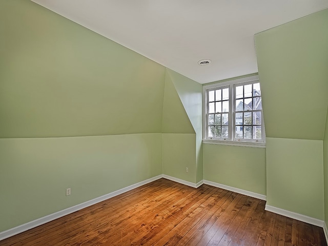 bonus room with wood-type flooring and vaulted ceiling