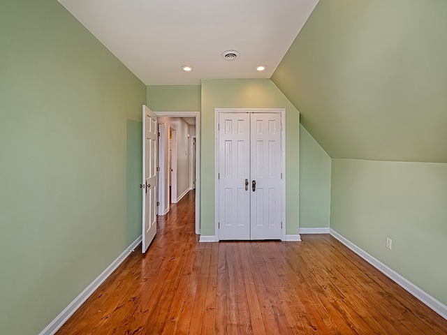 interior space featuring light hardwood / wood-style floors, lofted ceiling, and a closet