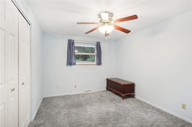 unfurnished bedroom featuring ceiling fan, a closet, and carpet