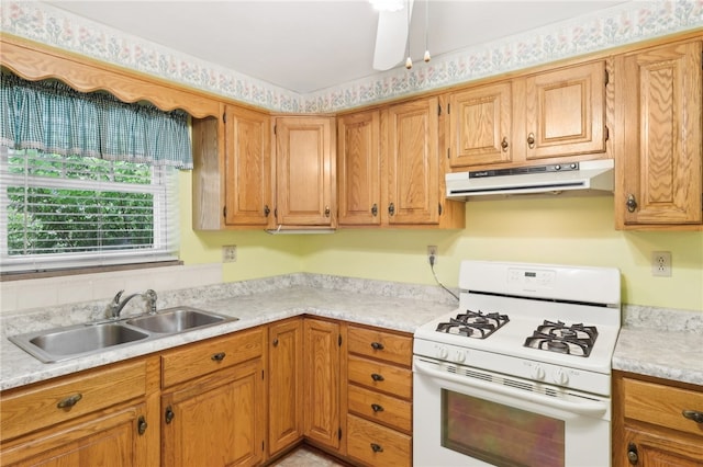 kitchen featuring white range with gas cooktop, sink, and ceiling fan