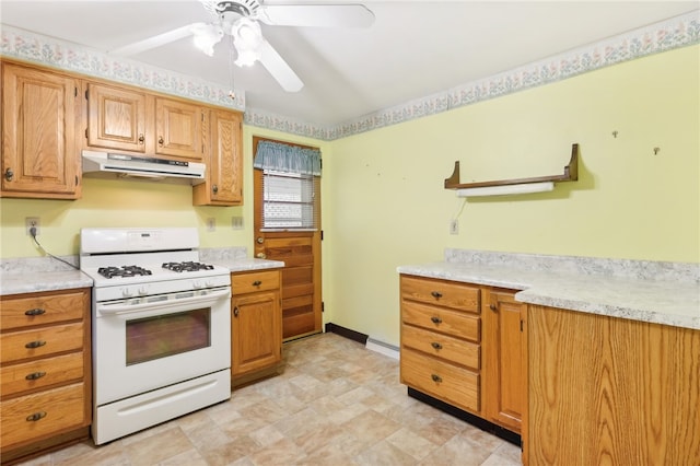 kitchen featuring a baseboard heating unit, ceiling fan, and gas range gas stove