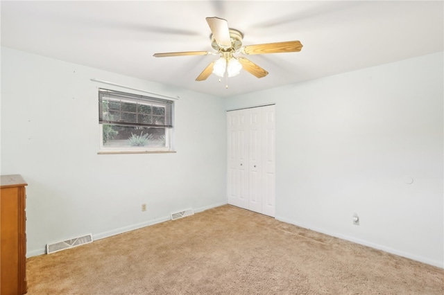 empty room with ceiling fan and light colored carpet