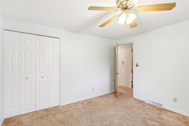 unfurnished bedroom featuring a closet, ceiling fan, and light colored carpet