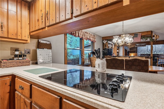 kitchen with an inviting chandelier, black electric stovetop, and hanging light fixtures