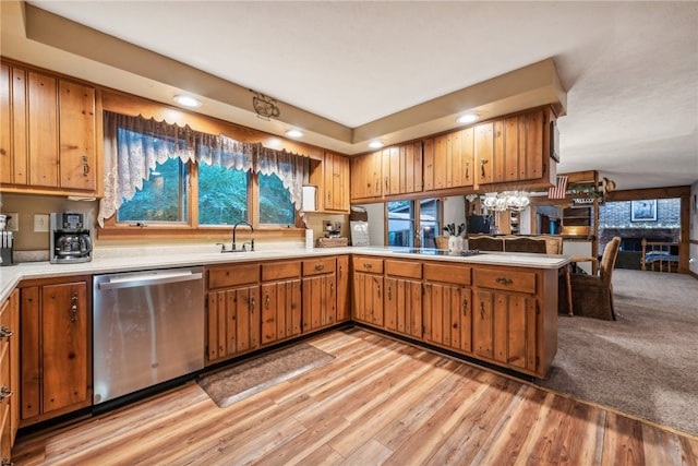 kitchen with kitchen peninsula, light wood-type flooring, stainless steel dishwasher, sink, and stovetop