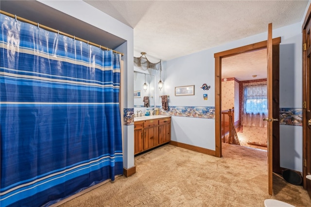 bathroom with a textured ceiling, vanity, and curtained shower