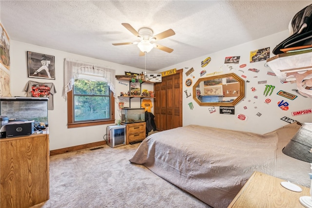 carpeted bedroom featuring a textured ceiling, ceiling fan, and a closet