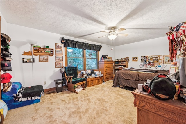 carpeted bedroom with ceiling fan and a textured ceiling