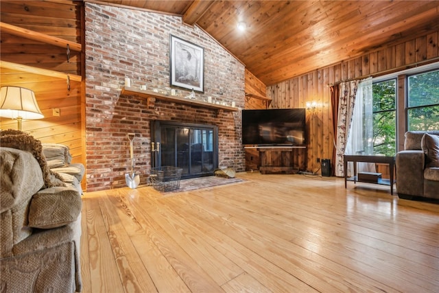 living room with vaulted ceiling with beams, a fireplace, light wood-type flooring, and wood ceiling