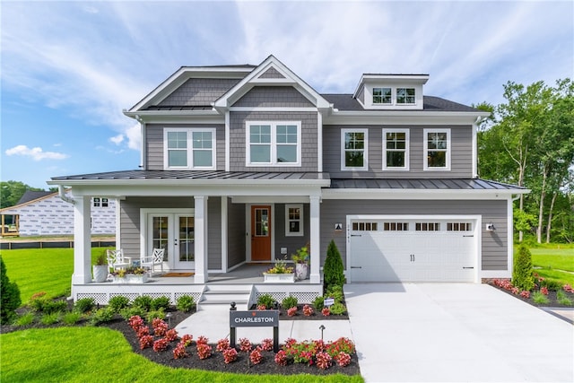 craftsman-style home with a front yard, covered porch, and a garage