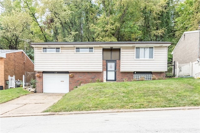 bi-level home featuring a garage and a front lawn