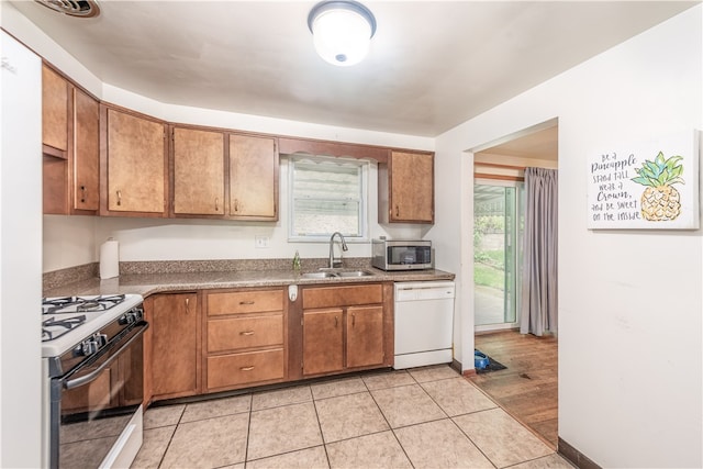 kitchen featuring black range with gas cooktop, white dishwasher, sink, and a wealth of natural light