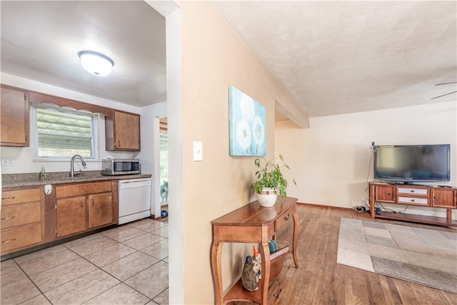 kitchen featuring light hardwood / wood-style flooring, white dishwasher, and sink