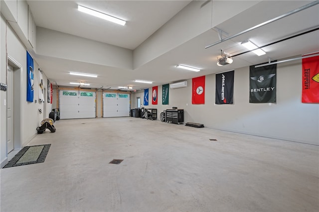 garage with a garage door opener and an AC wall unit