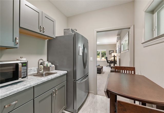 kitchen featuring light carpet, stainless steel appliances, and sink