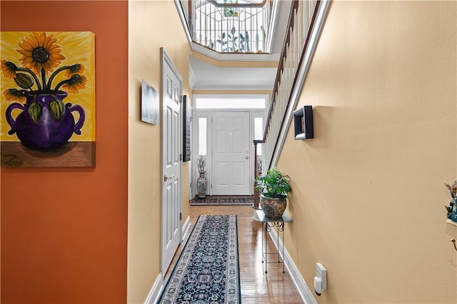 entryway with an inviting chandelier, a towering ceiling, hardwood / wood-style flooring, and a healthy amount of sunlight