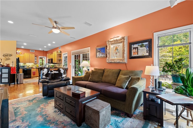 living room with ceiling fan and light hardwood / wood-style flooring