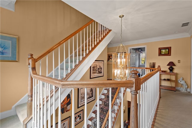 staircase with ornamental molding, a chandelier, and carpet