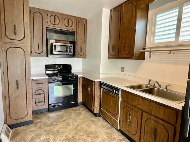 kitchen with dishwashing machine, sink, and black gas range oven