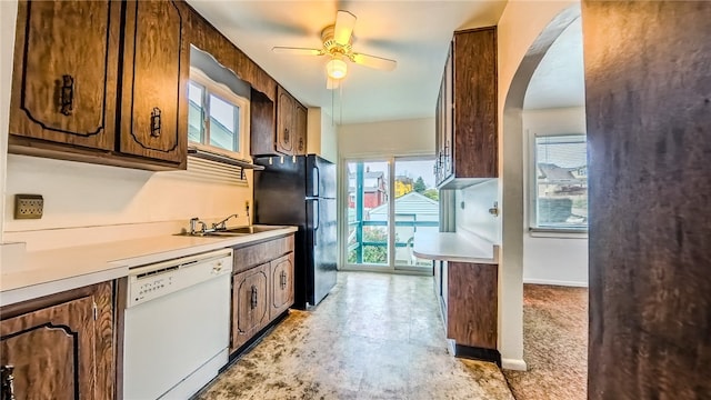 kitchen with black fridge, a wealth of natural light, sink, and white dishwasher