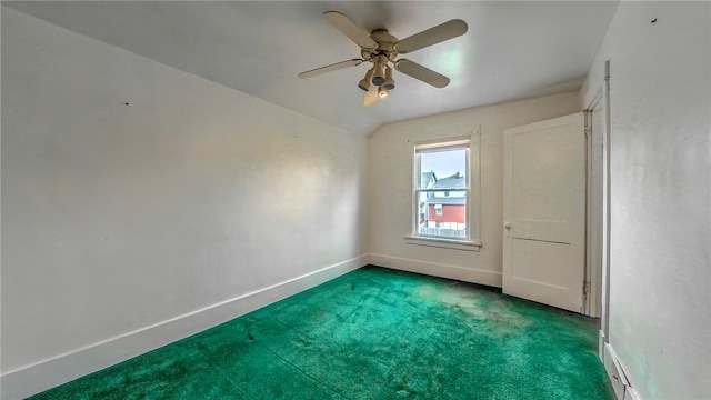 carpeted spare room featuring ceiling fan and vaulted ceiling