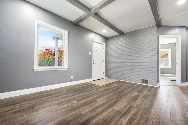 interior space with beam ceiling, brick wall, and dark hardwood / wood-style floors