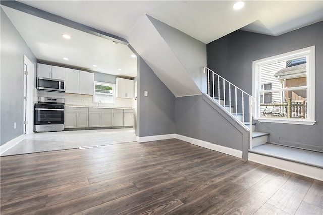 unfurnished living room featuring sink and hardwood / wood-style floors