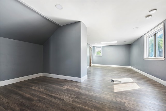 bonus room with lofted ceiling, dark hardwood / wood-style flooring, and a wealth of natural light