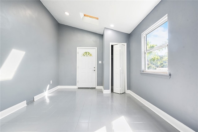 tiled foyer featuring vaulted ceiling