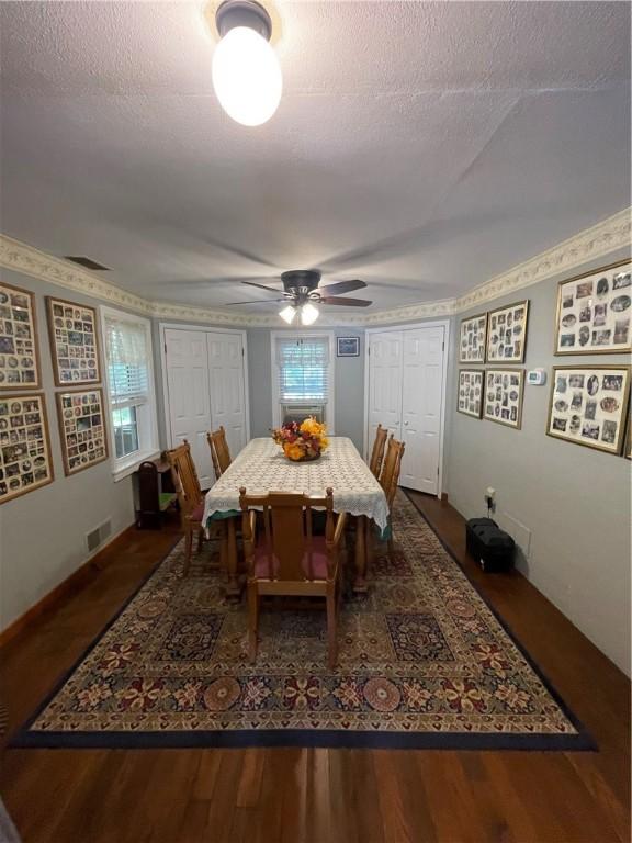 dining room featuring ceiling fan, dark hardwood / wood-style flooring, and a textured ceiling