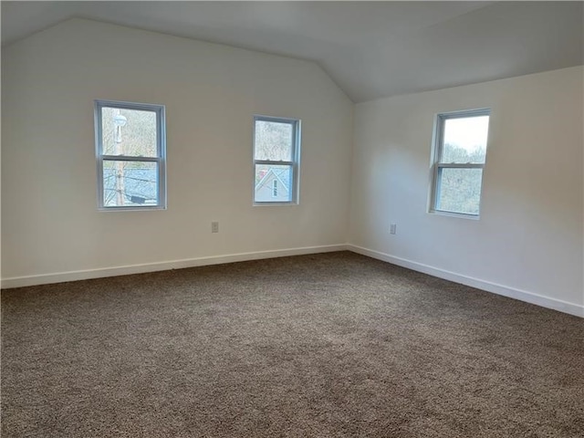 carpeted empty room with lofted ceiling