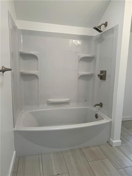 bathroom with shower / tub combination and vaulted ceiling