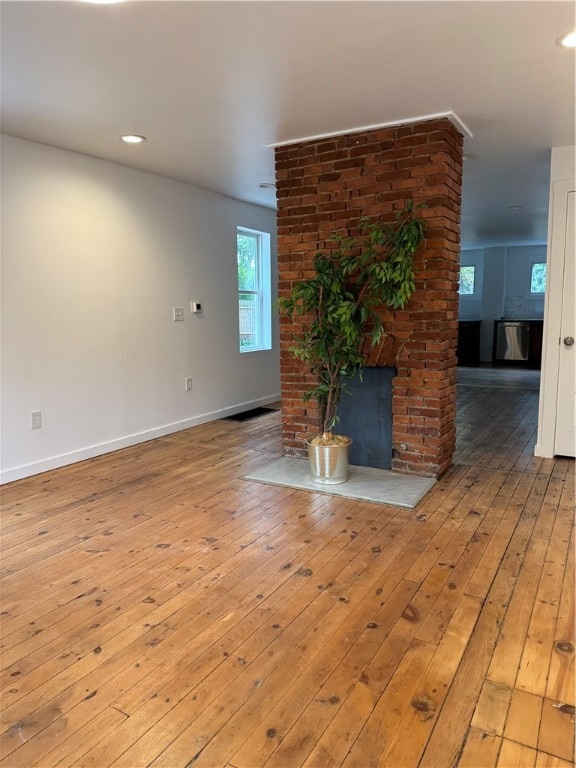 unfurnished living room with a fireplace and light hardwood / wood-style floors