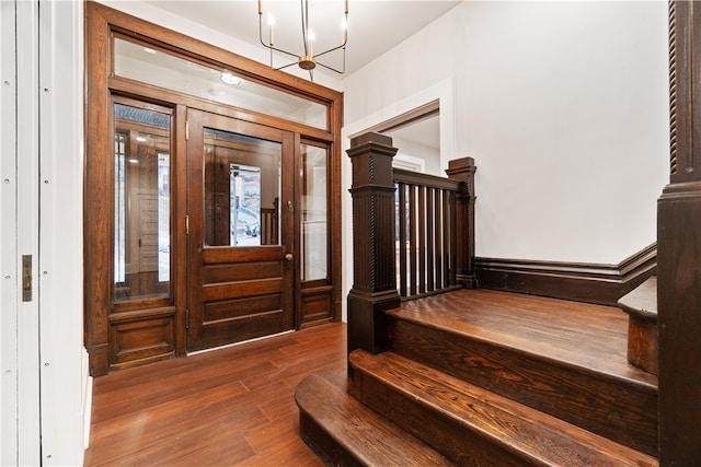 entrance foyer with an inviting chandelier and hardwood / wood-style floors