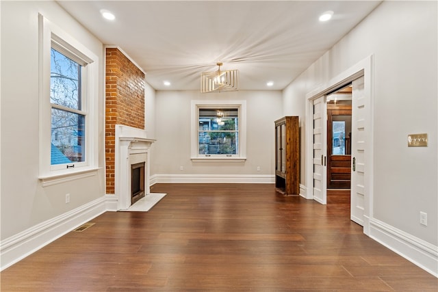 unfurnished living room featuring dark wood-type flooring and a chandelier