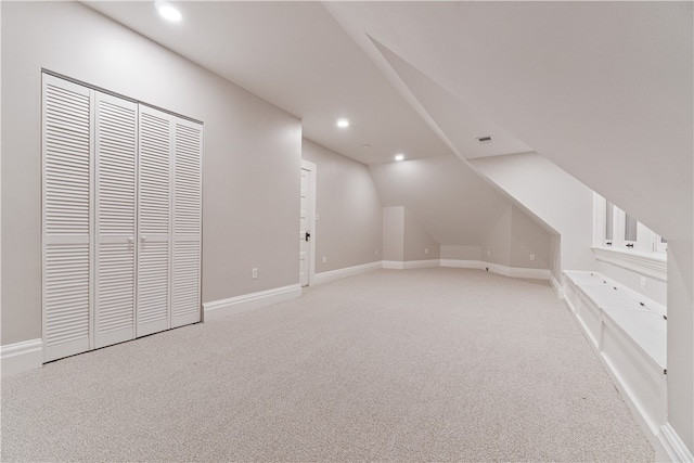 additional living space with vaulted ceiling and light colored carpet