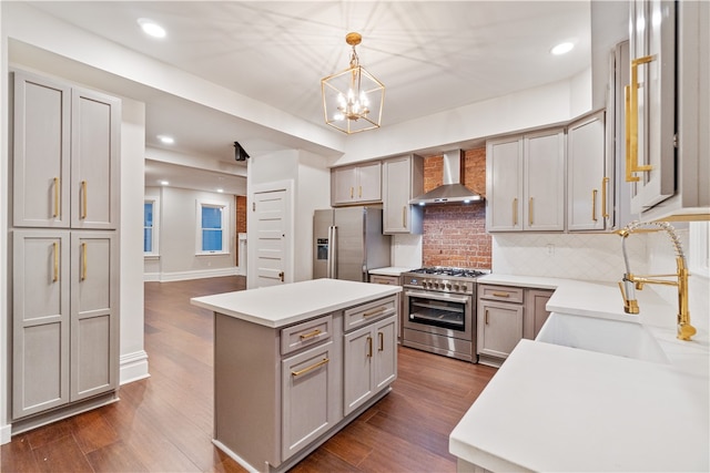 kitchen with sink, gray cabinetry, wall chimney range hood, stainless steel appliances, and dark hardwood / wood-style flooring