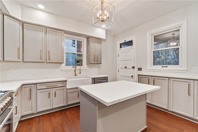 kitchen with stainless steel appliances, a chandelier, dark wood-type flooring, and a kitchen island