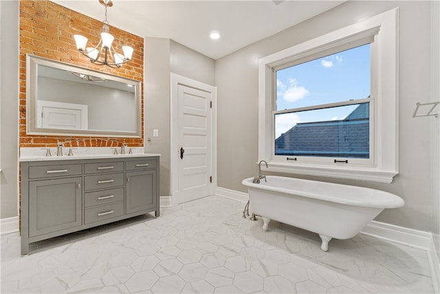 bathroom with an inviting chandelier, brick wall, vanity, and a bathing tub