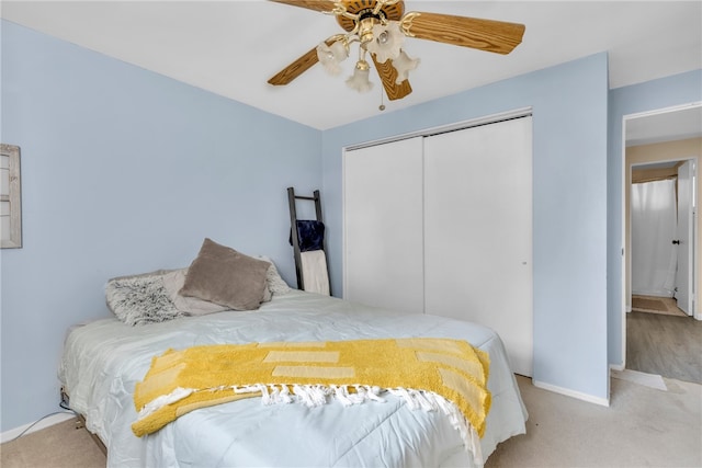 bedroom with ceiling fan, light colored carpet, and a closet