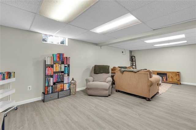 living room featuring a paneled ceiling and hardwood / wood-style floors