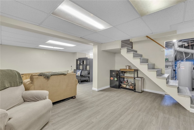 living room with light hardwood / wood-style flooring and a paneled ceiling