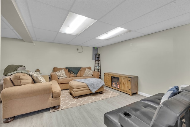 living room with a drop ceiling and hardwood / wood-style floors