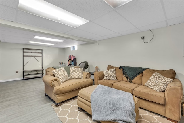 living room featuring a drop ceiling and wood-type flooring